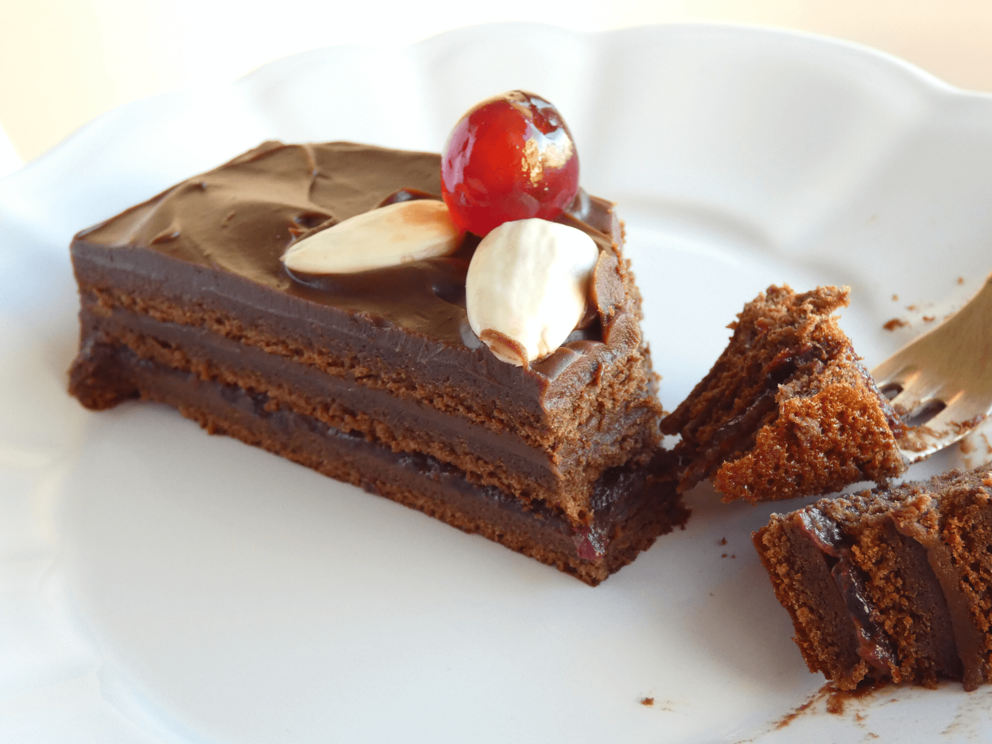 Mazurek czekoladowy przekrój ciasta na talerzu z dekoracją