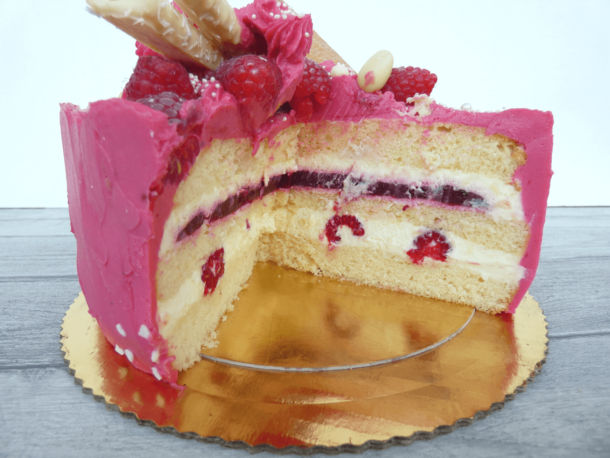 Tort malinowy w przekroju widok warstw kremu i owoców